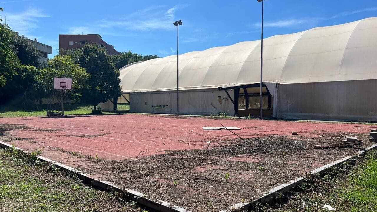Impianto sportivo Valentina Caruso a Roma prima della rigenerazione, tensostruttura e campo degradati.